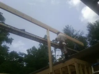 Carpenter setting a ridge beam over a new addition frame — Ice Dam Removal by Roofing Brothers in Killingworth
