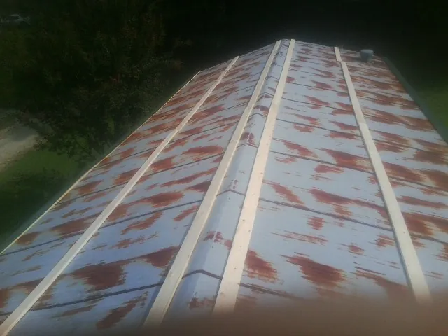 Rusted metal roof panels with new wood purlins before replacement — Storm Damage Roof Repair in Killingworth by Roofing Brothers