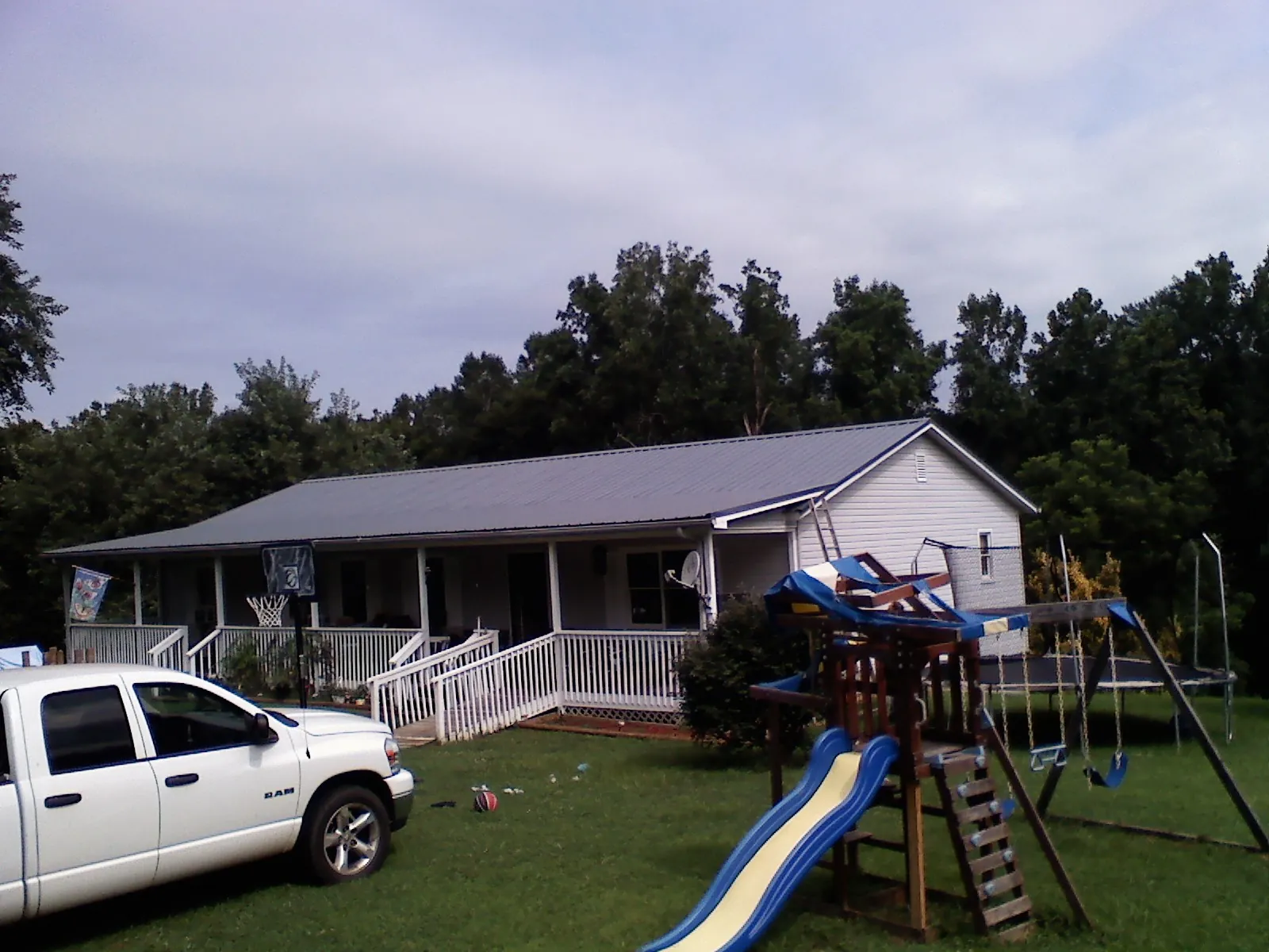 Dark metal roof on a country home with a full length front porch in Killingworth