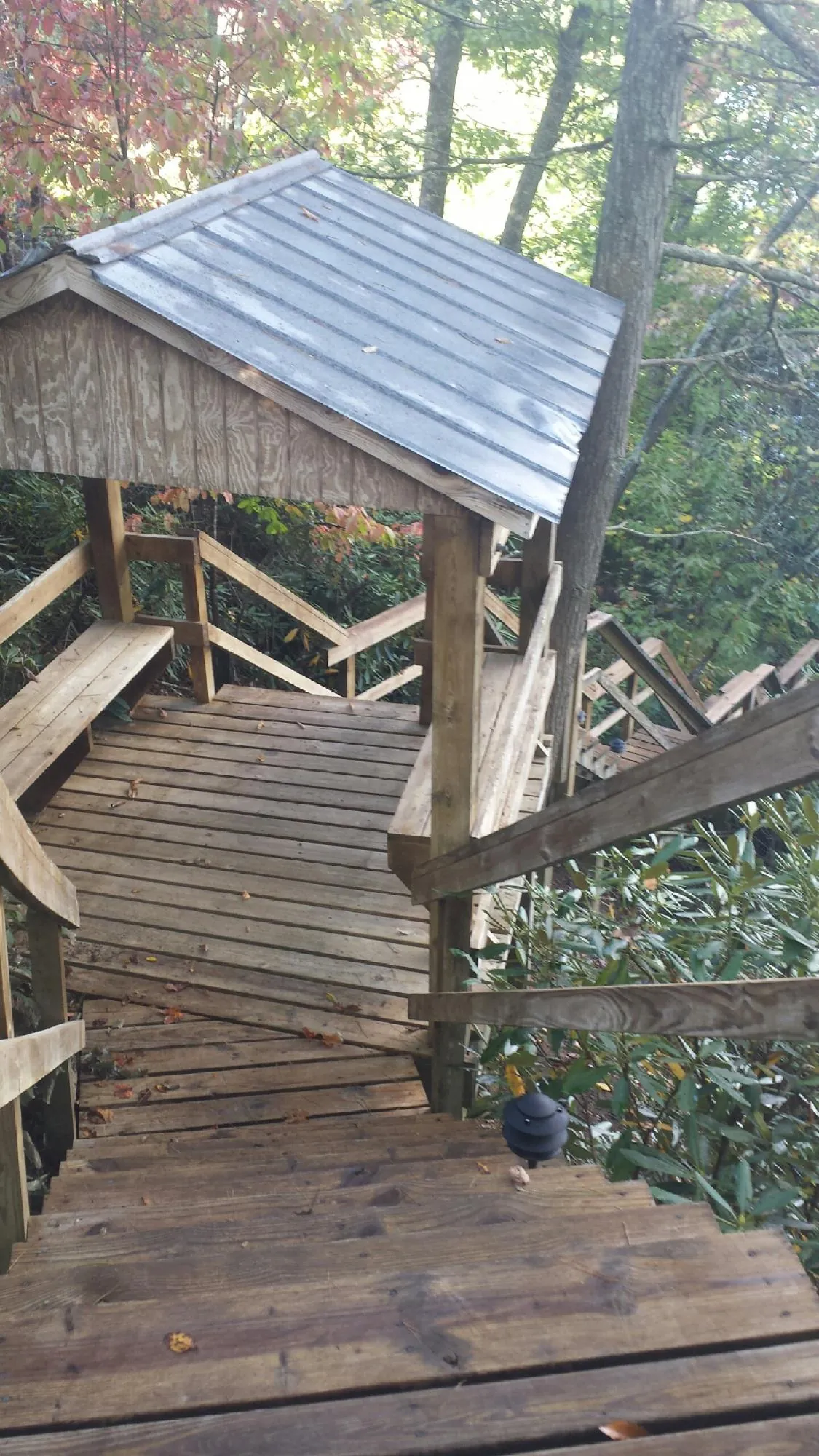 Metal roofed shelter over wooden steps on a wooded walkway — Skylight Repair & Installation work by our crew in Killingworth