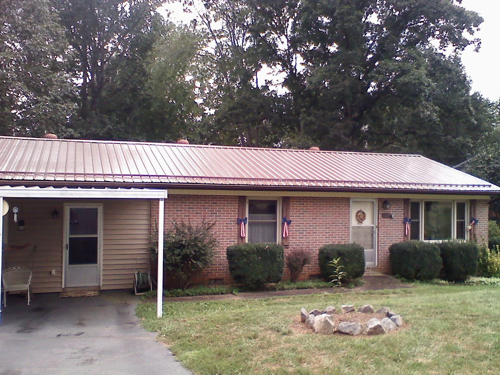 Bronze metal roof and carport on a brick ranch home — Roof Repair work by our crew in Killingworth